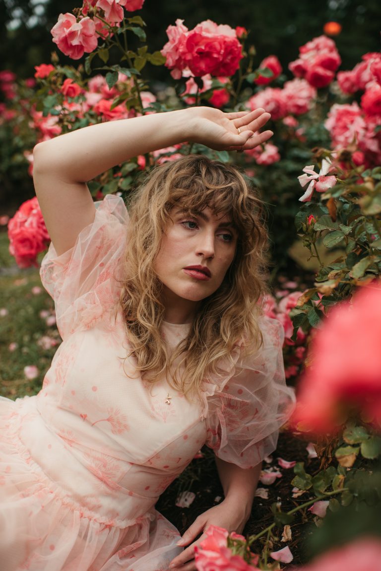 Woman in Simone Rocha x H&M Puff Sleeve Dress in a rose garden